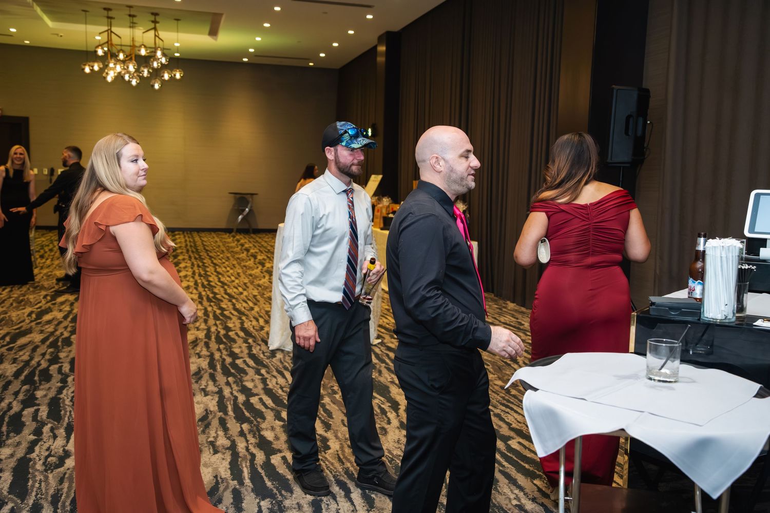 A collage of elegant reception photos showing guests mingling and socializing at a formal event in a grand ballroom.