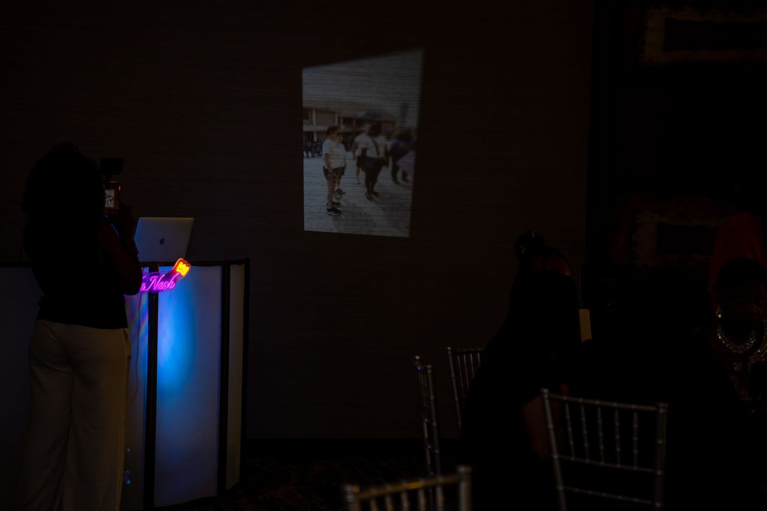 A dark room with a glowing blue LED light strip mounted near the ceiling illuminates the space.