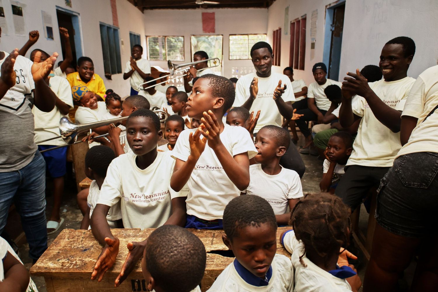 Students in white shirts enthusiastically participate in a classroom activity.