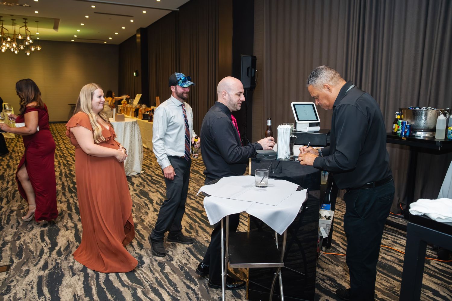 Guests mingling and networking at an elegant indoor corporate event with dim lighting and modern decor.