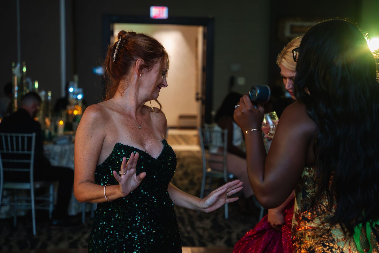 People dancing and socializing at a dimly lit evening party or reception event.