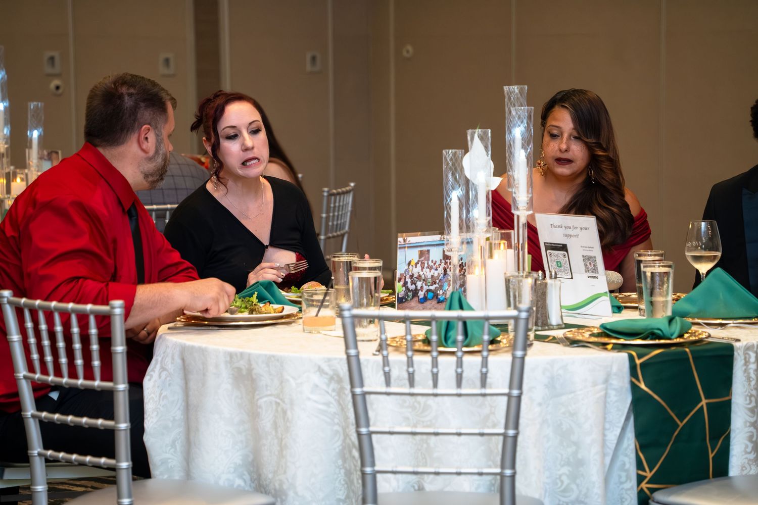 Wedding reception guests seated at decorated tables with white linens and centerpieces in an elegant banquet hall.