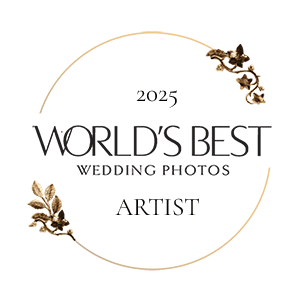 A circular gold logo design for World's Best Wedding Photos Artist 2025 with decorative floral accents.