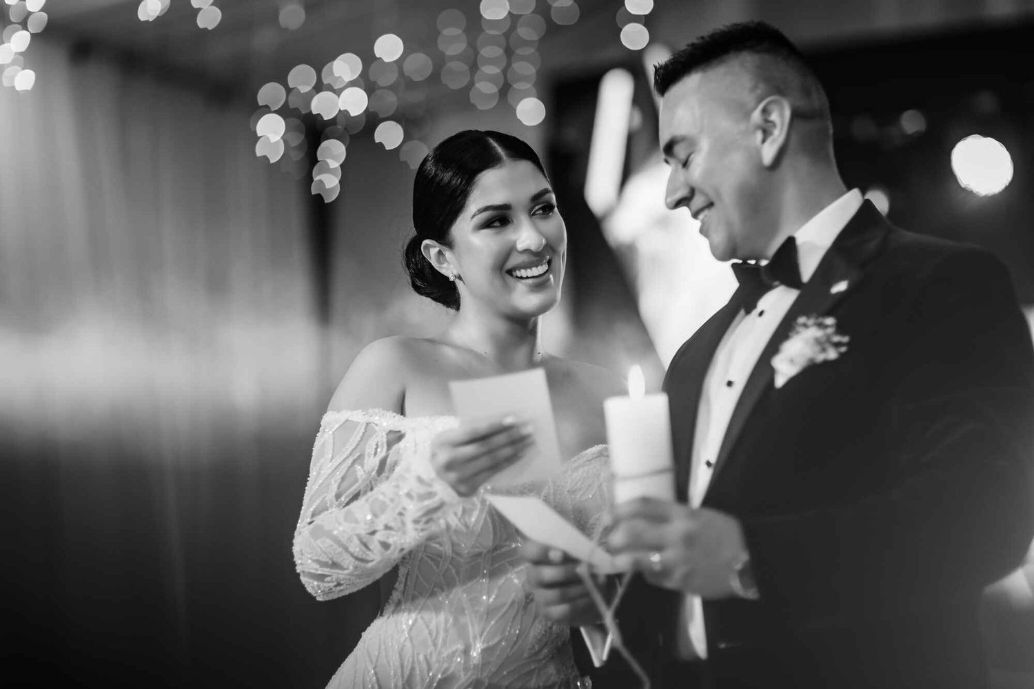 Pareja de novios sonríe durante la ceremonia de bodas leyendo votos