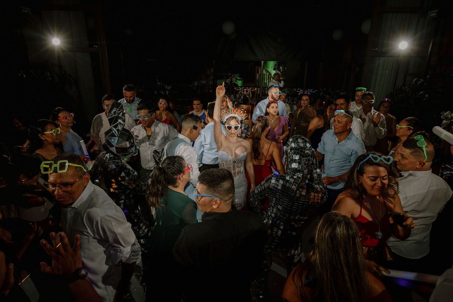 Invitados bailando con la novia en el centro y ambiente animado durante la fiesta de boda.