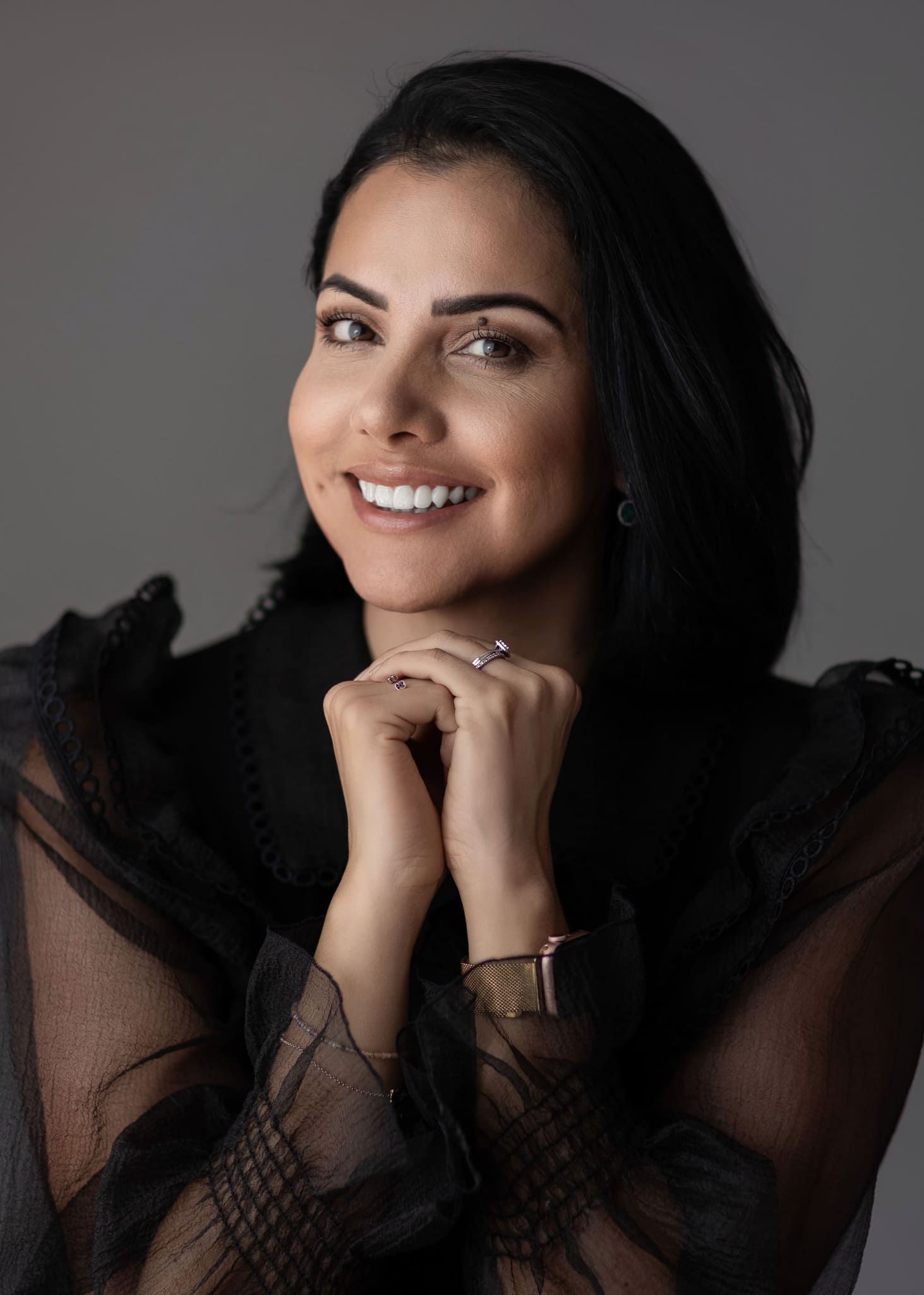 Retrato de estudio primer plano de mujer sonriente en negro, transmitiendo elegancia en Pereira. — John Palacio