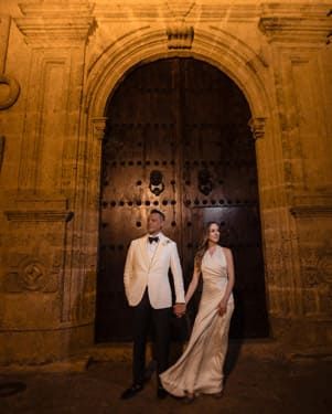 Cartagena wedding photographer capturing newlyweds in front of a colonial door in the walled city, night portrait