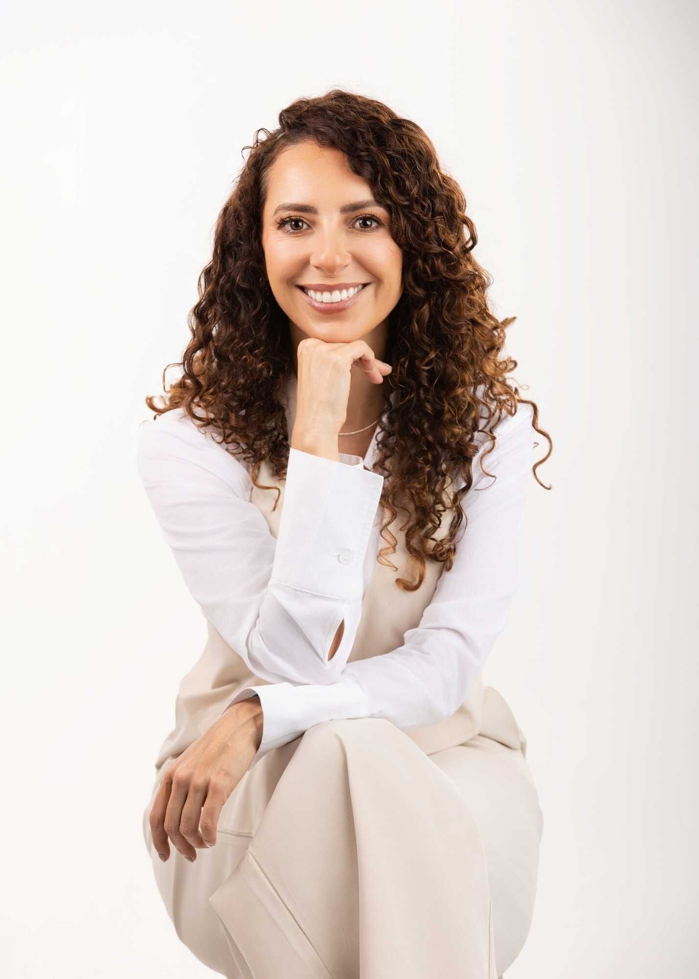 Retrato radiante de mujer profesional con cabello rizado, emanando calidez y cercanía en Pereira. — John Palacio