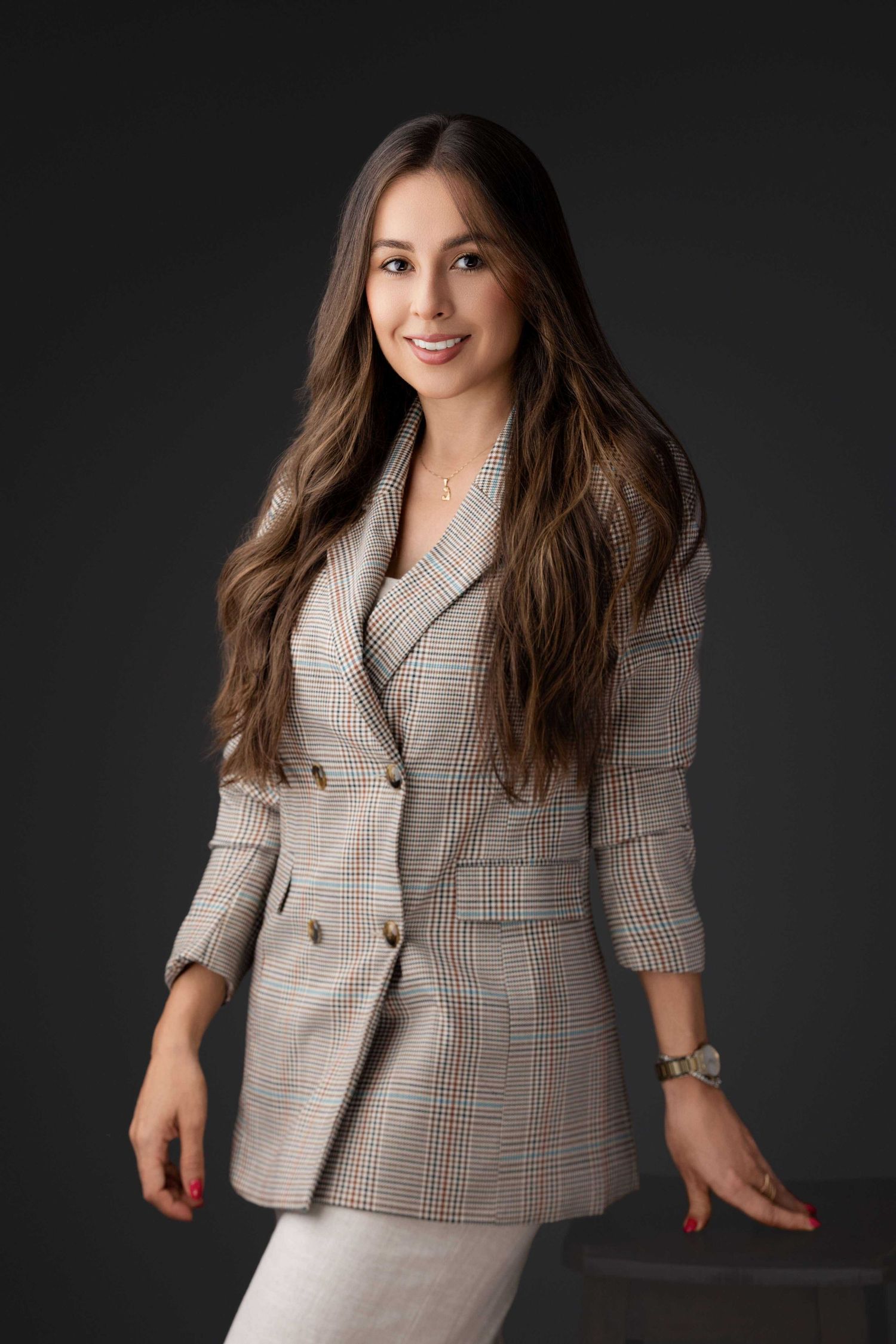 Retrato de estudio profesional que muestra una chaqueta a cuadros y un vestido blanco sobre un fondo oscuro - John Palacio