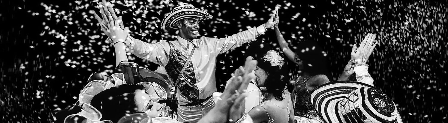 Cartagena wedding photographer capturing a cumbia dance during the reception, guests wearing sombrero vueltiao celebrating amid confetti, b