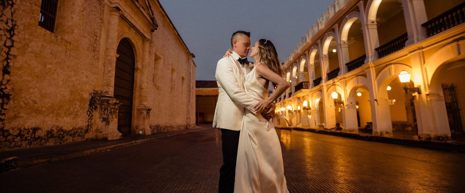 Newlywed couple in Cartagena’s walled city, nighttime portrait with illuminated colonial architecture