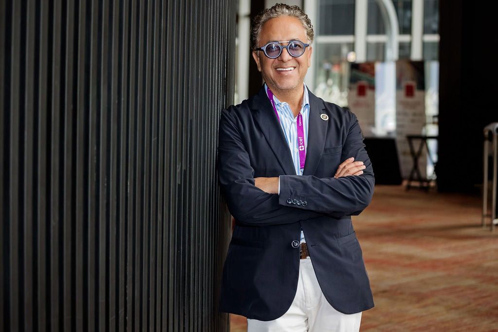 Ejecutivo con estilo y gafas azules posando con confianza en un evento corporativo en Pereira. — John Palacio