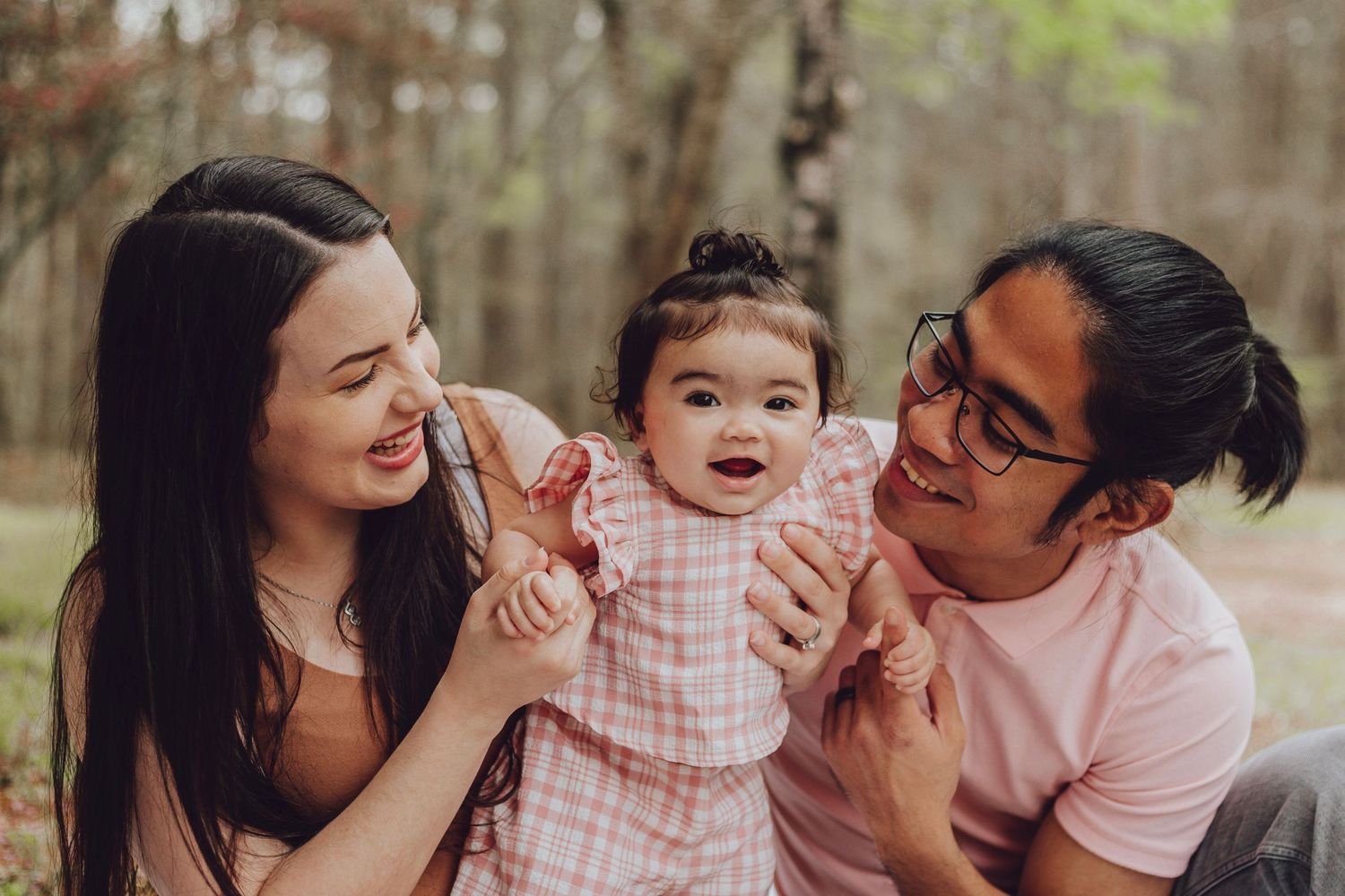 A family shares laughter and cuddles during an intimate photo session.