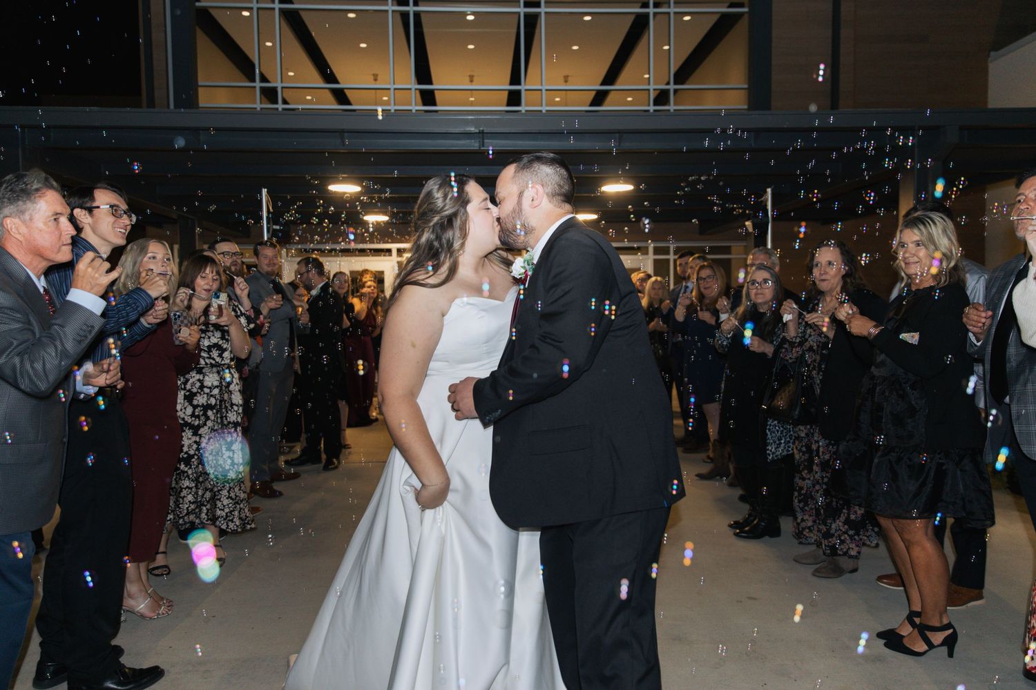 Wedding reception dance with confetti falling in dimly lit venue.