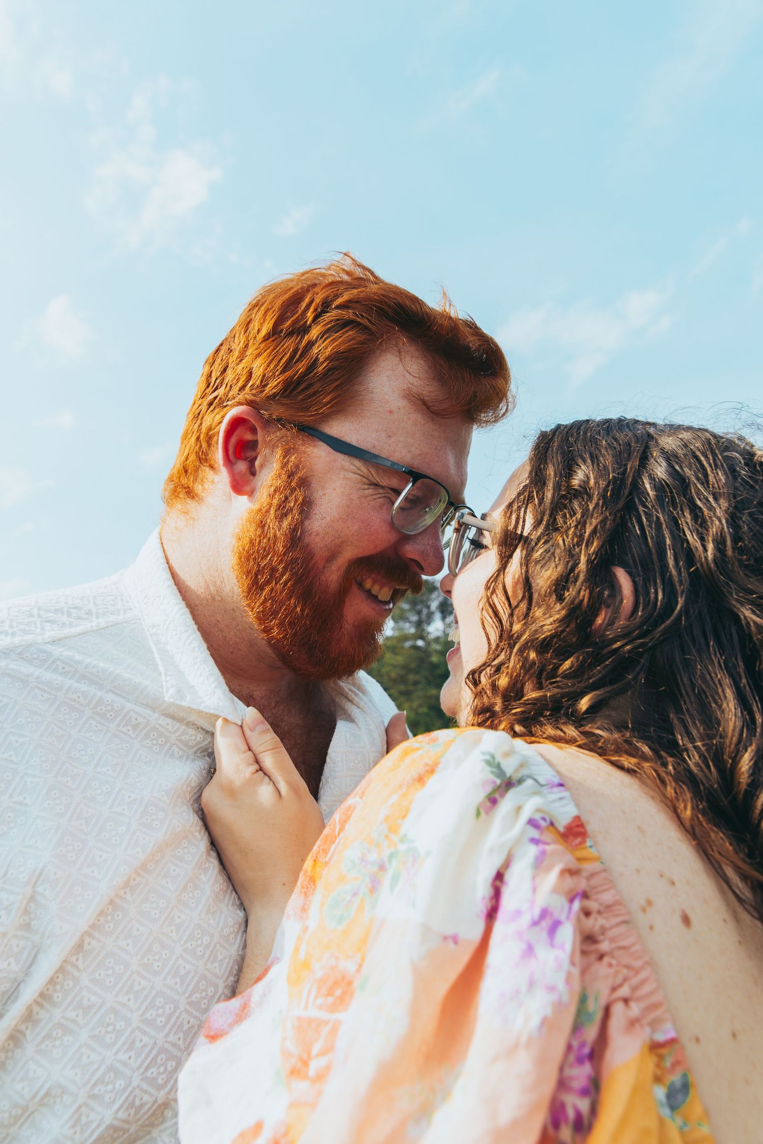Couple leaning in for a kiss during a bright summer afternoon