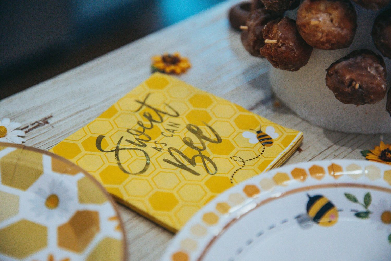 Chocolate cake pops arranged on yellow honeycomb-patterned paper with decorative elements.