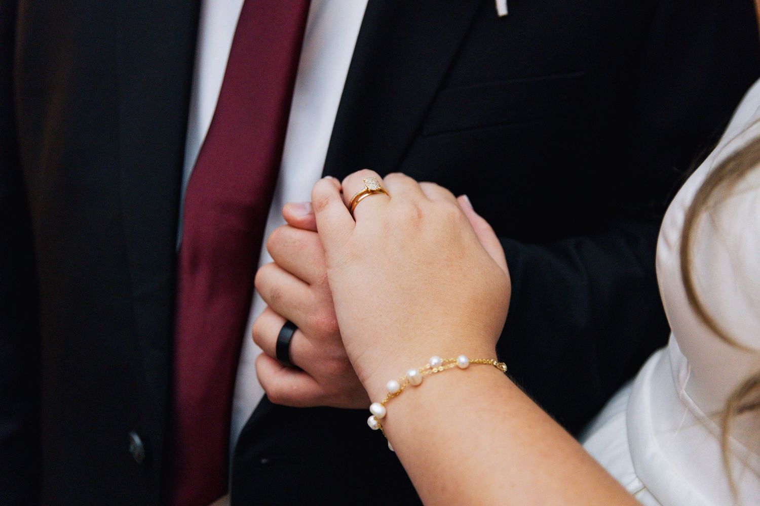 Close-up shot of hands showing wedding bands.