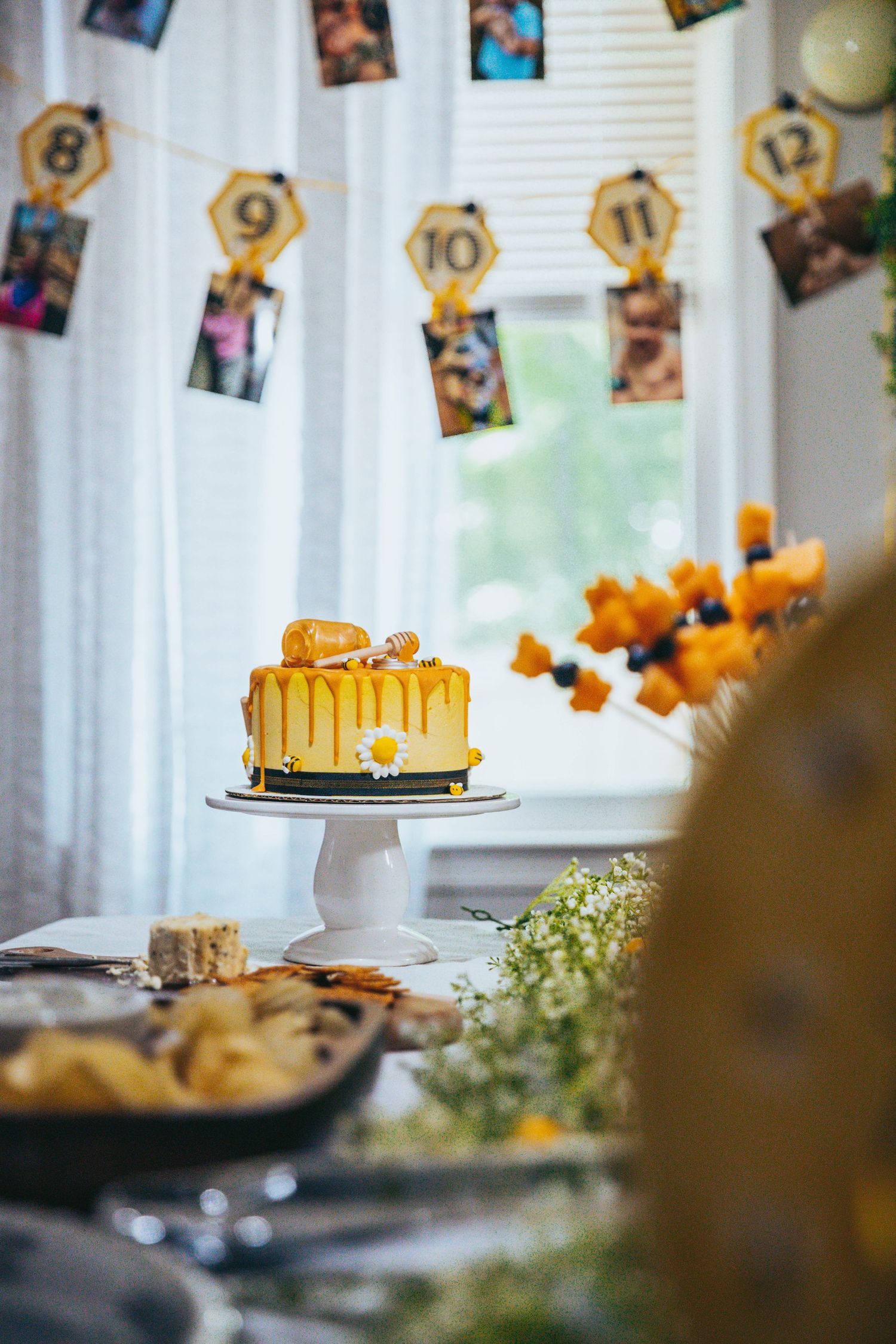 A decorative fall table setting with orange accents and hanging photo cards creates a cozy autumn atmosphere.