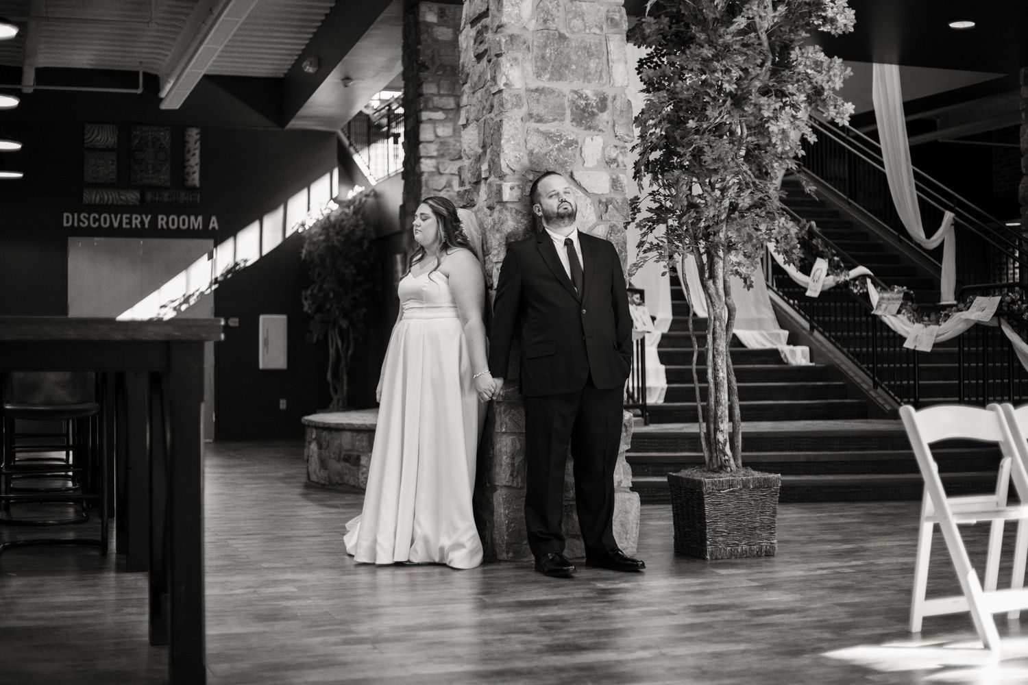Black and white wedding photo in an elegant indoor venue.