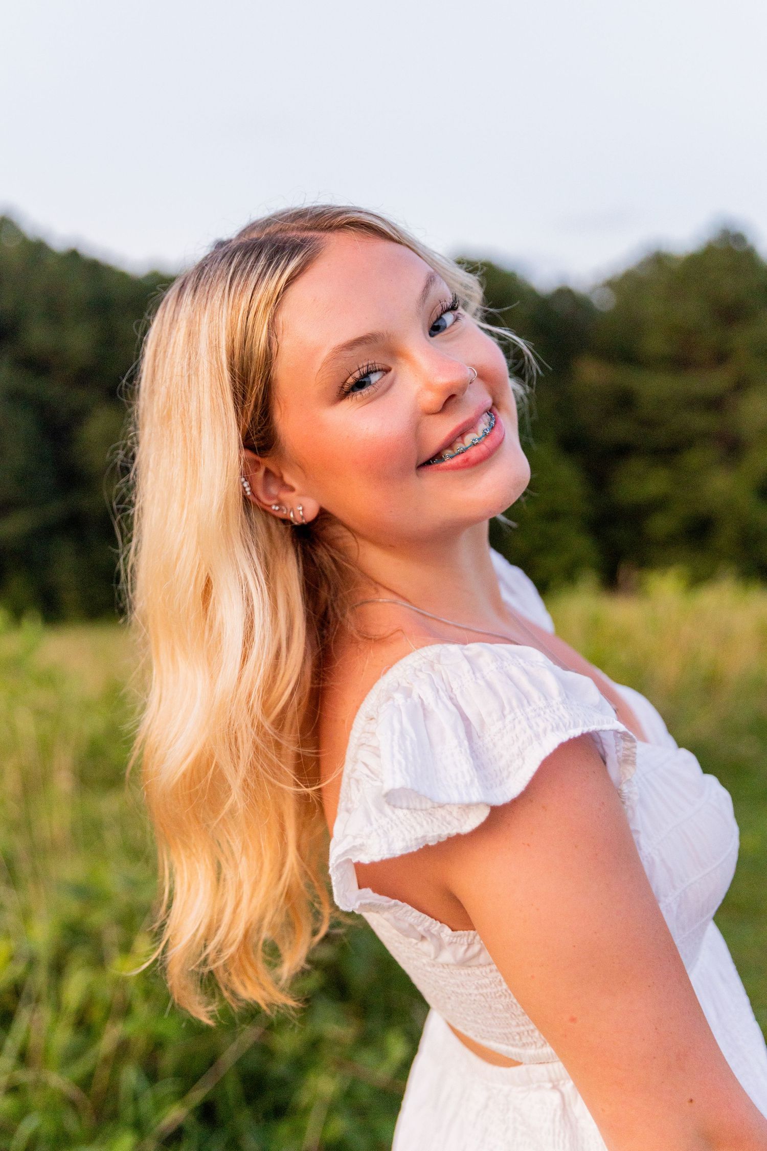 Natural light portrait session in a field during golden hour with soft summer lighting.