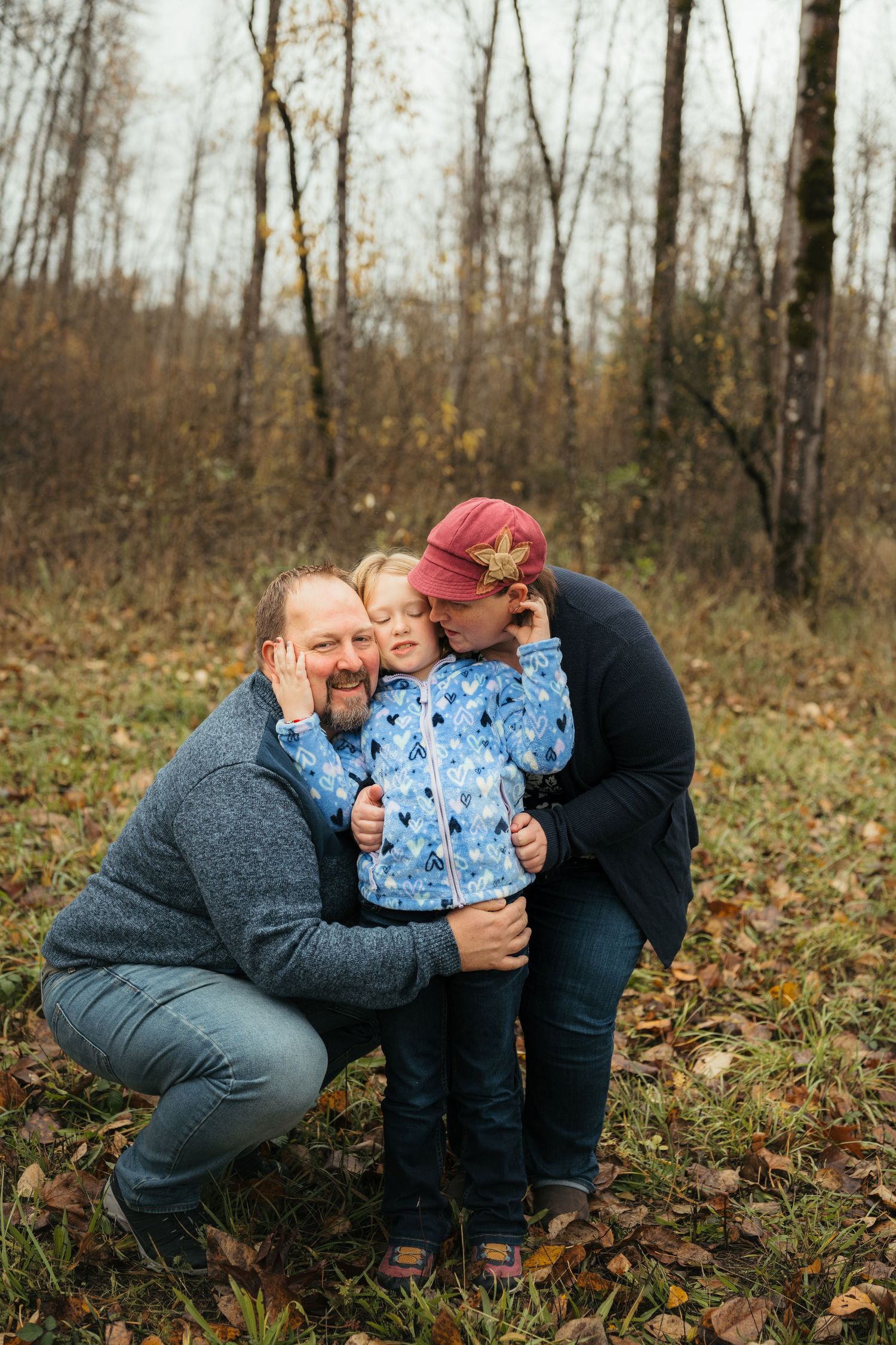 Sweet family embrace captured during fall photoshoot in a wooded setting.