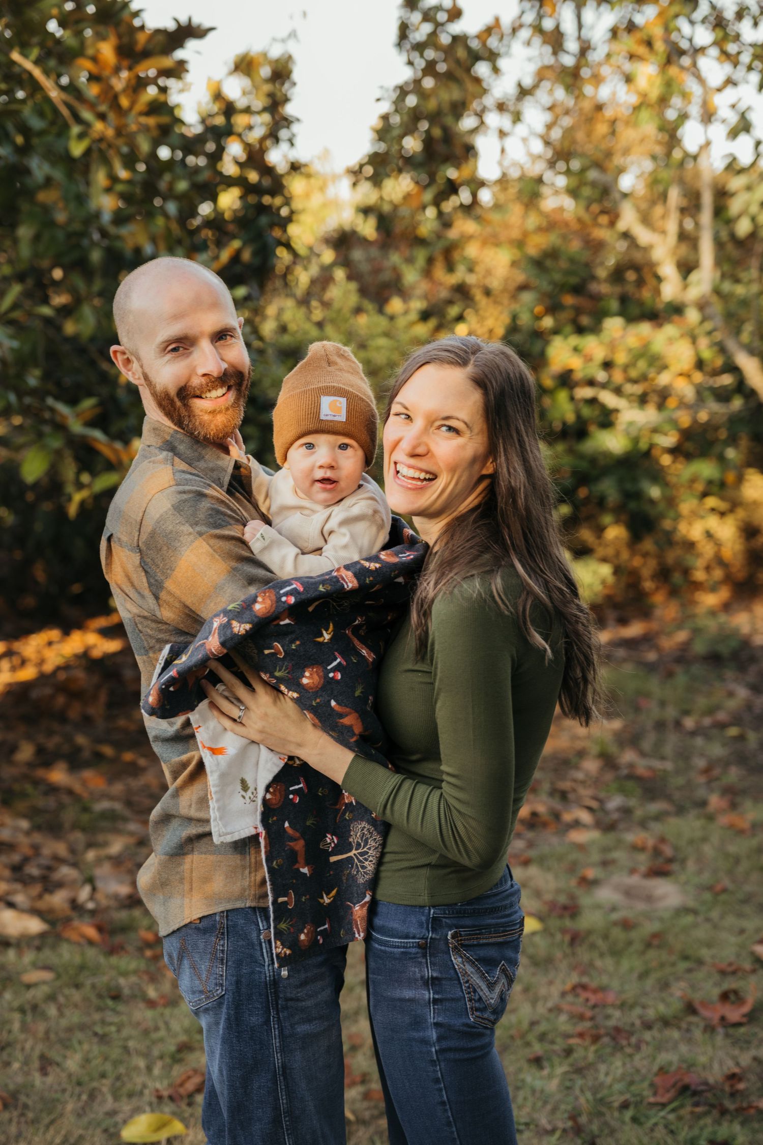 Happy family of three enjoying an autumn day outdoors together.