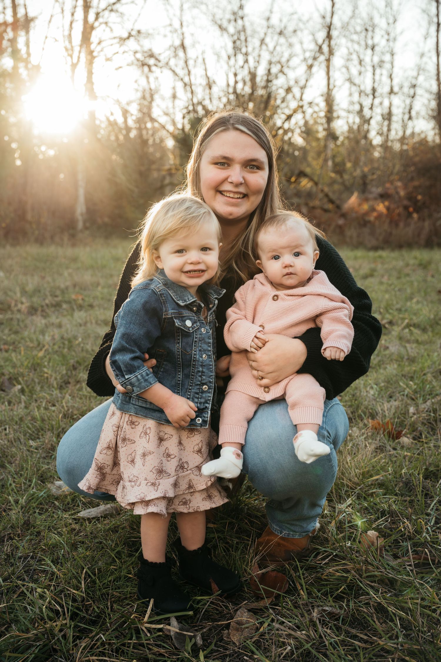 Candid outdoor family photos in a field at sunset with children and casual denim attire.
