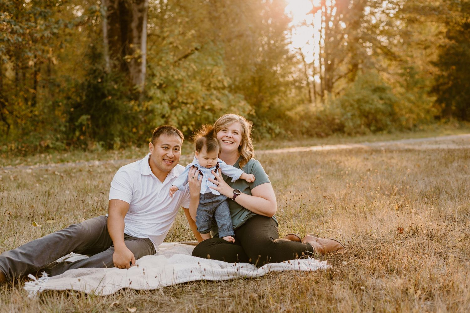 Relaxed outdoor picnic scene on a blanket in a golden-lit forest clearing.