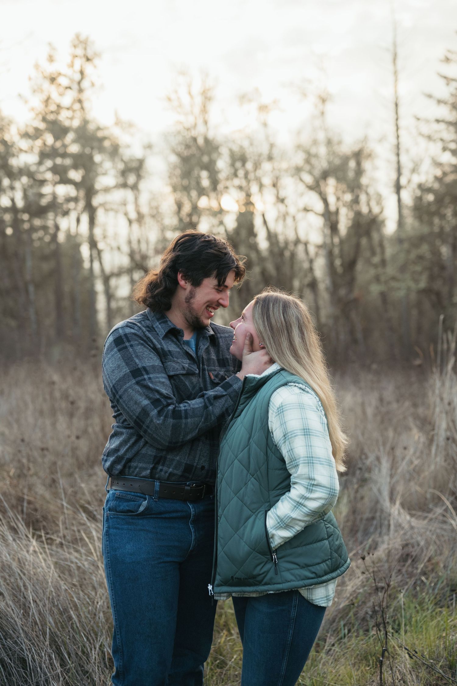 Intimate moment between couple in rustic outdoor setting during winter.