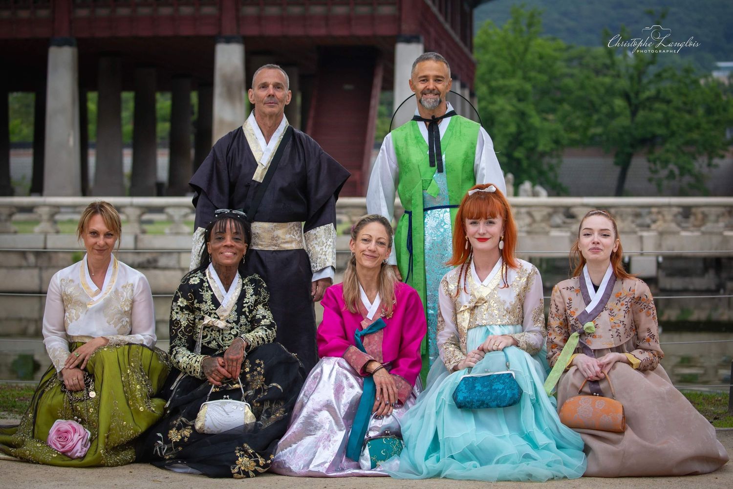 Group photo of people wearing traditional Korean hanbok clothing outside a temple.