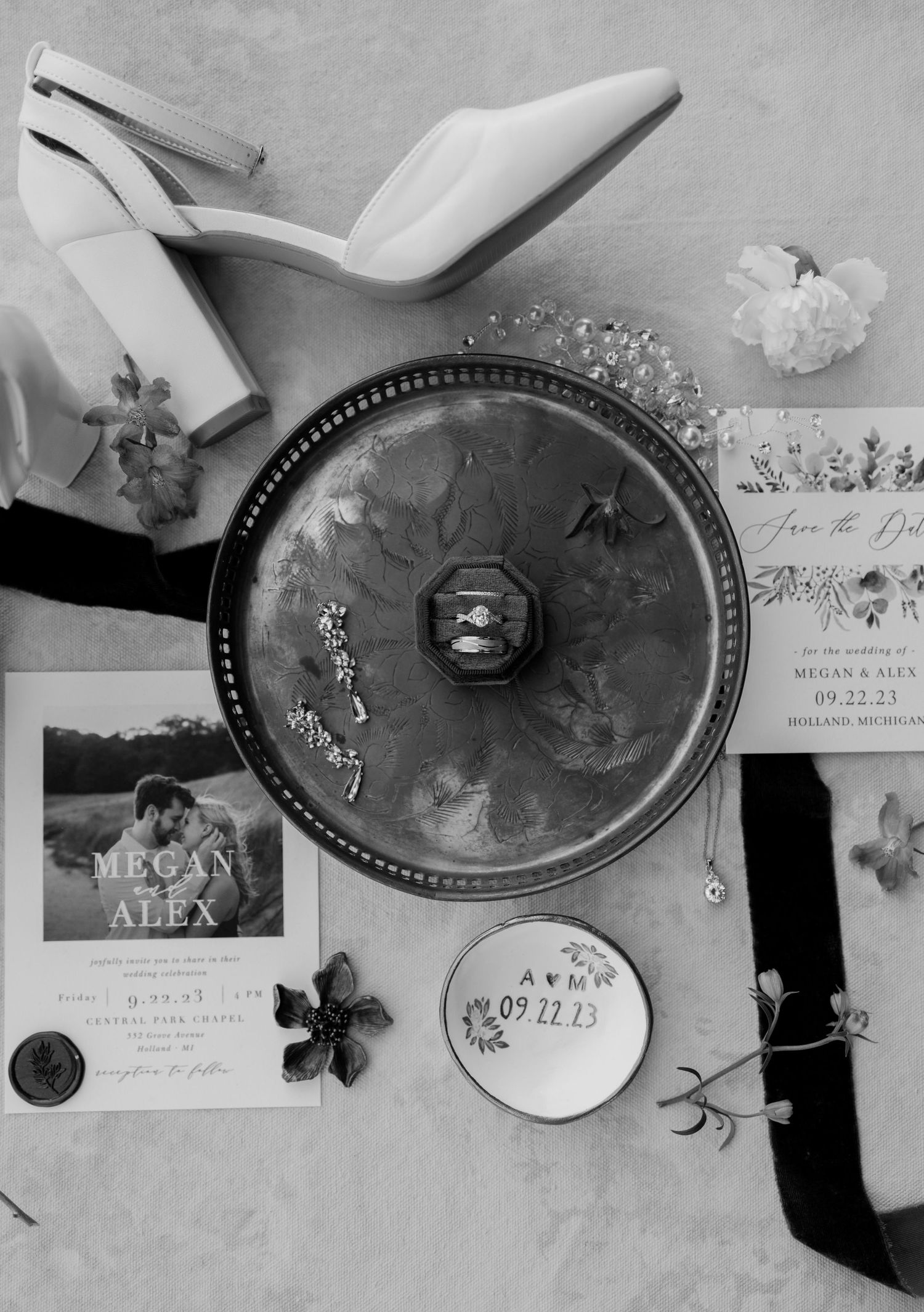 Flat lay of wedding details featuring rings, invites, shoes, and florals. Kayla Ann Photography Holland Michigan Port 393.