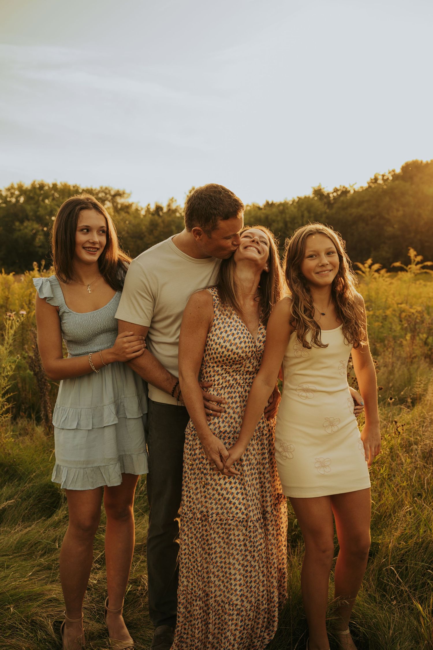 Family enjoying golden hour together in a field during sunset, captured in multiple candid poses.