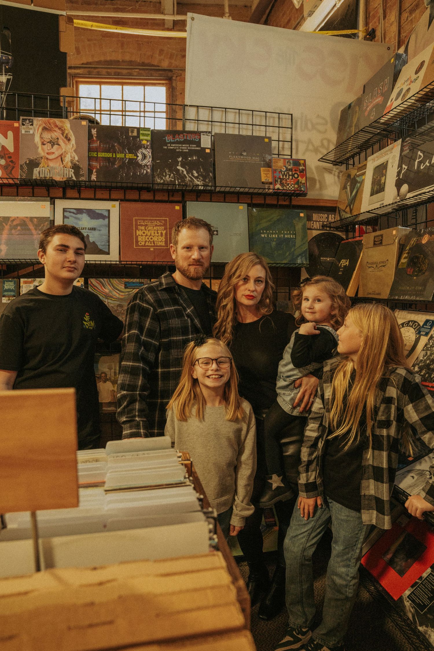 A group of people browsing together in a cozy bookstore with wooden shelves and warm lighting.