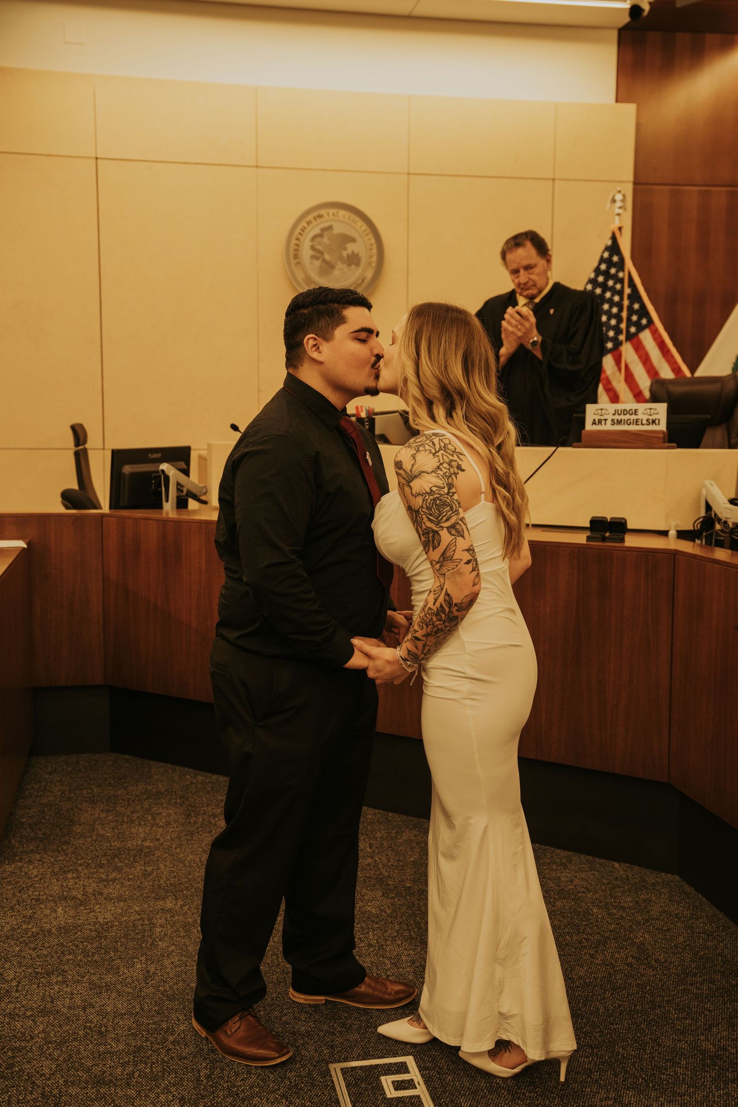 A couple shares an intimate moment during their courthouse wedding ceremony in a government building.
