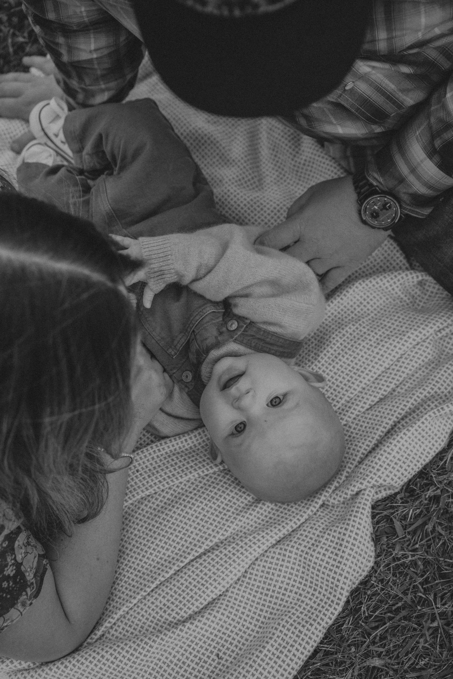 A sequence of black and white photographs showing a baby lying on a polka dot blanket.