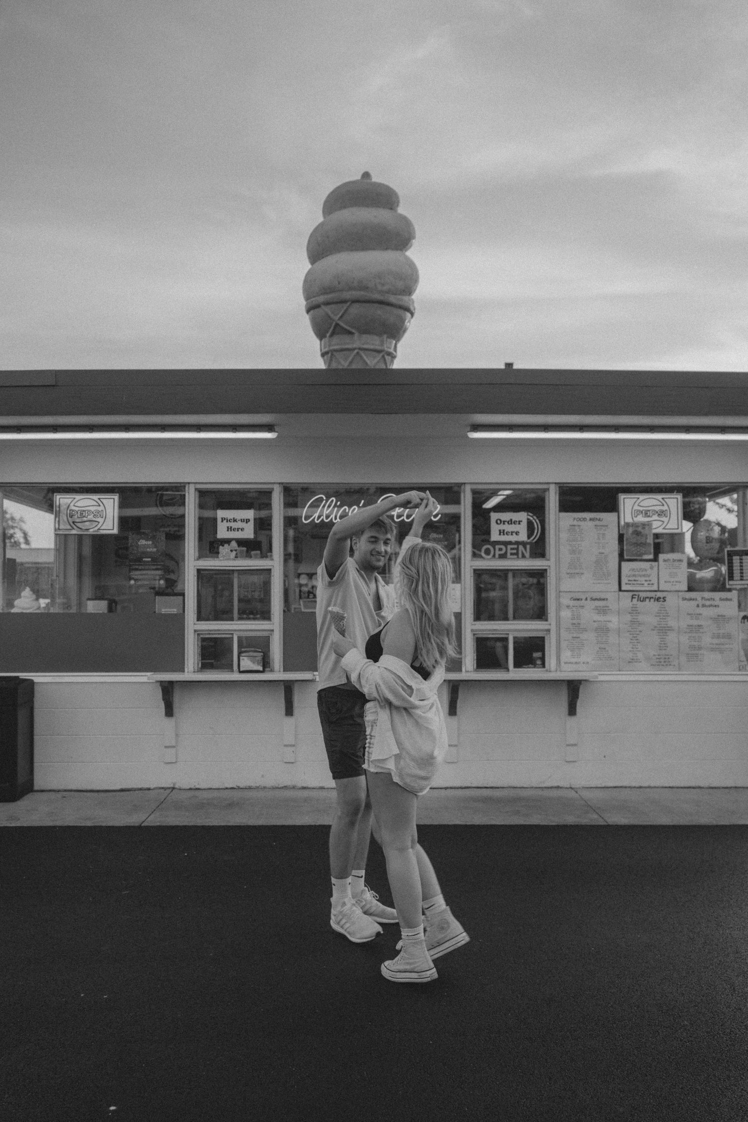 A black and white photo sequence showing figures walking past a retro-style diner or restaurant exterior with signage.