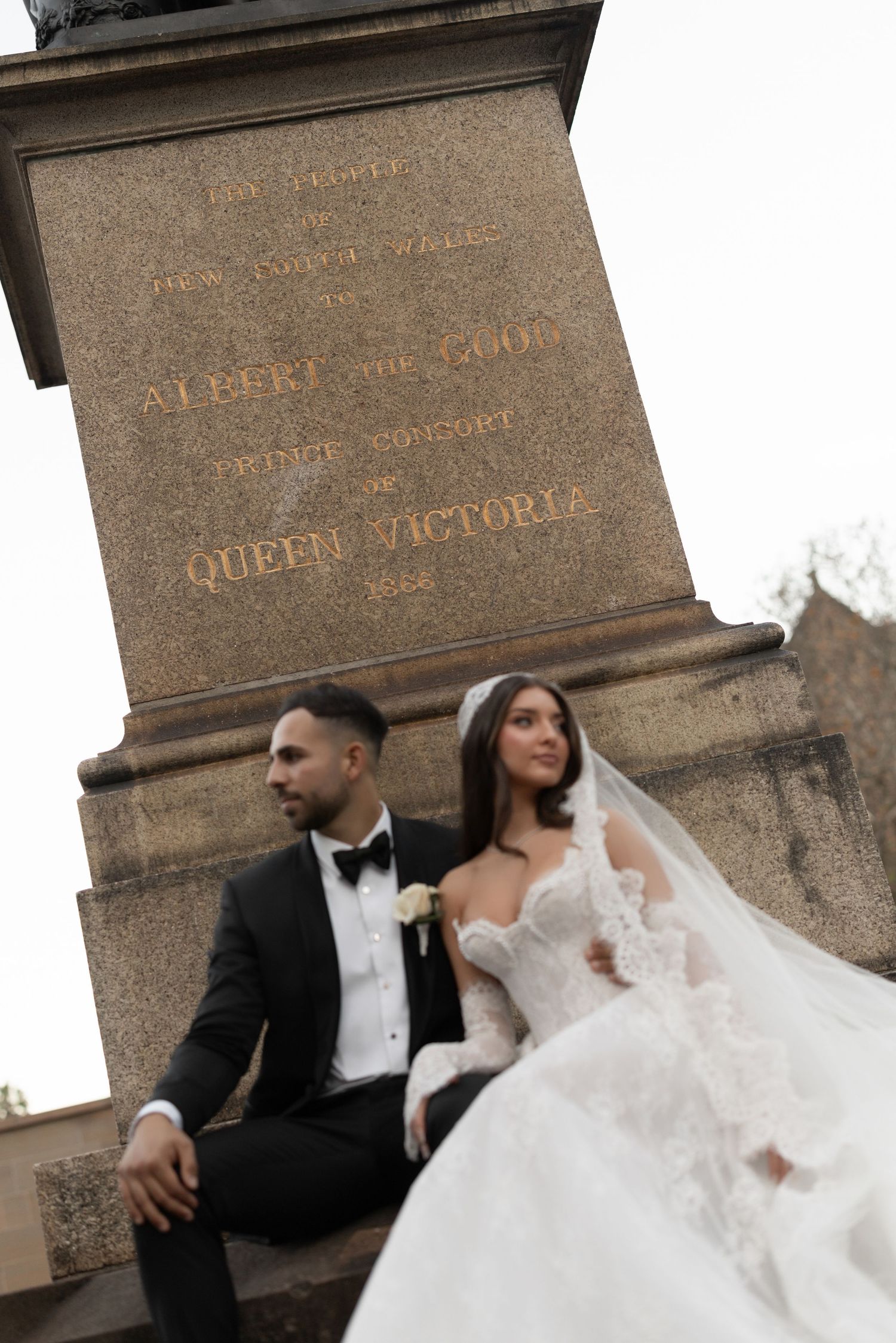Bride and groom pose at the Albert the Good Prince Consort of Queen Victoria monument in London.