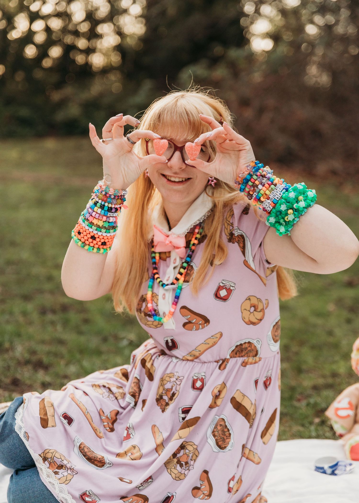 Colorful beaded bracelets and a food-themed dress create a playful outdoor style with a joyful summer vibe.