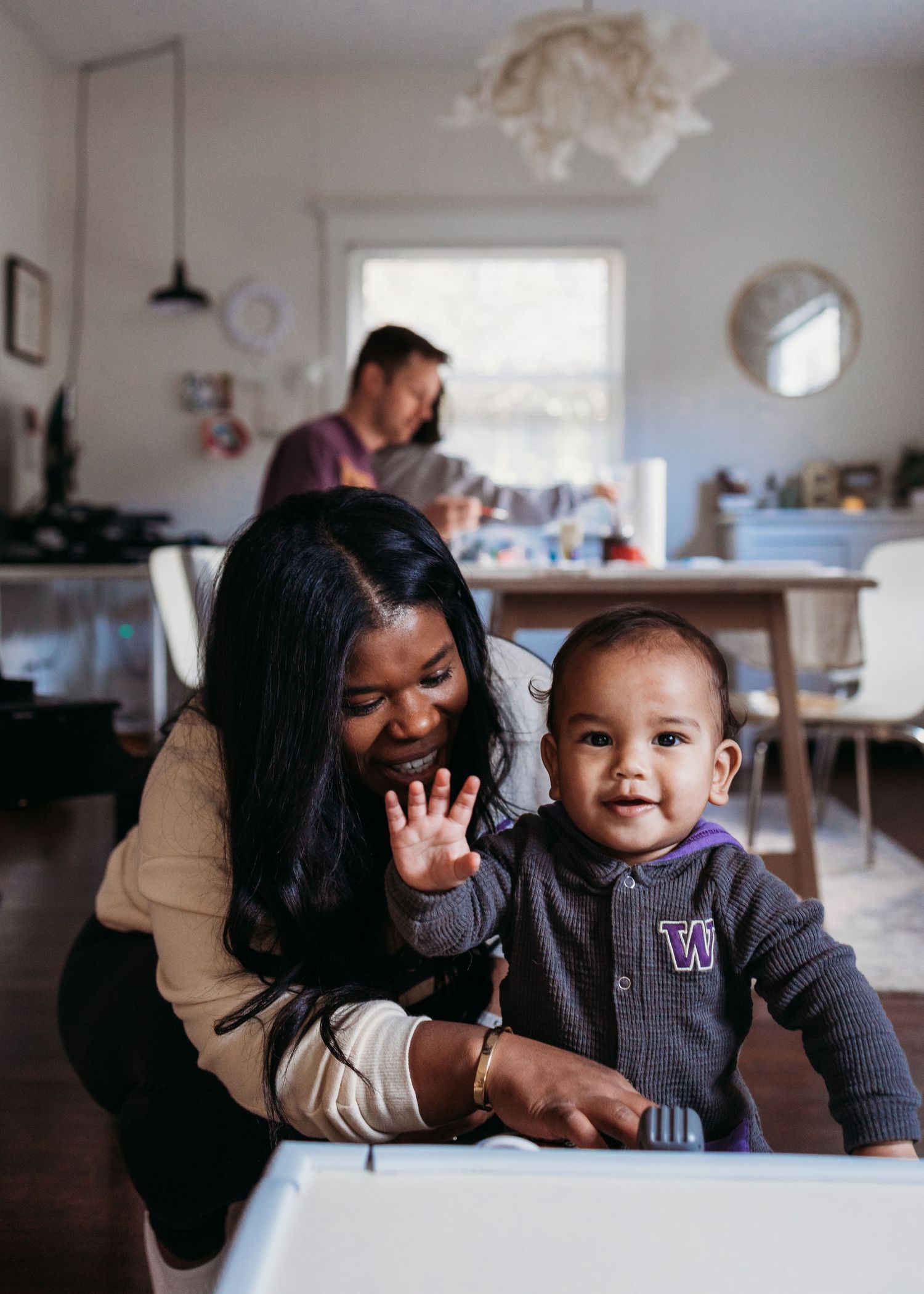 A joyful family moment shared around a table in a cozy home kitchen with natural light coming through the window.