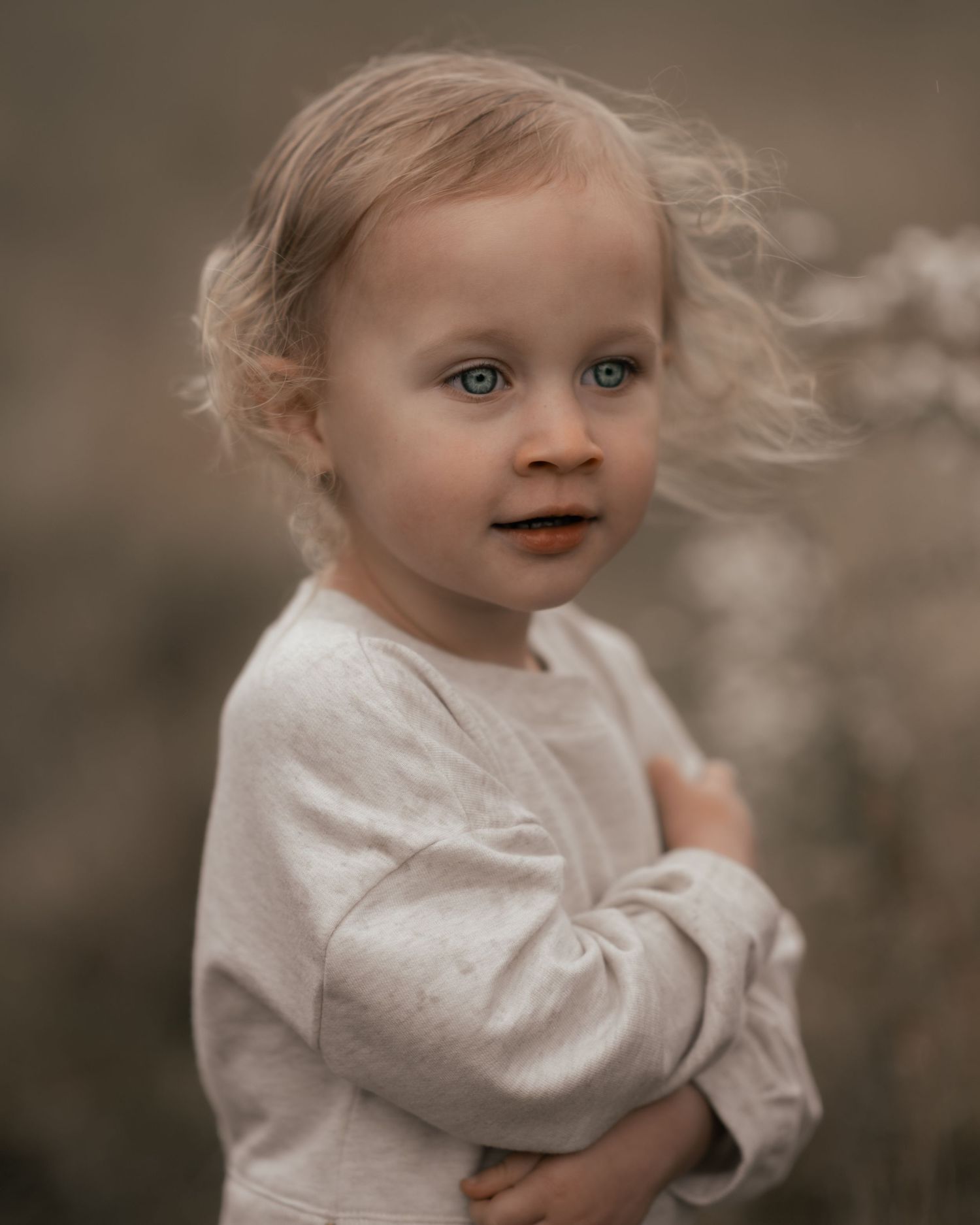 Portrait of young child in white dress with soft, dreamy lighting.