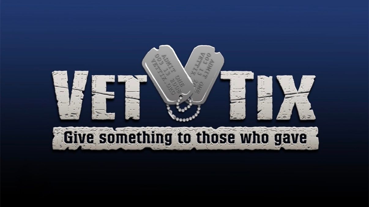 A row of navy blue banners with silver VET TIX logos and military-themed text displayed on a wall.