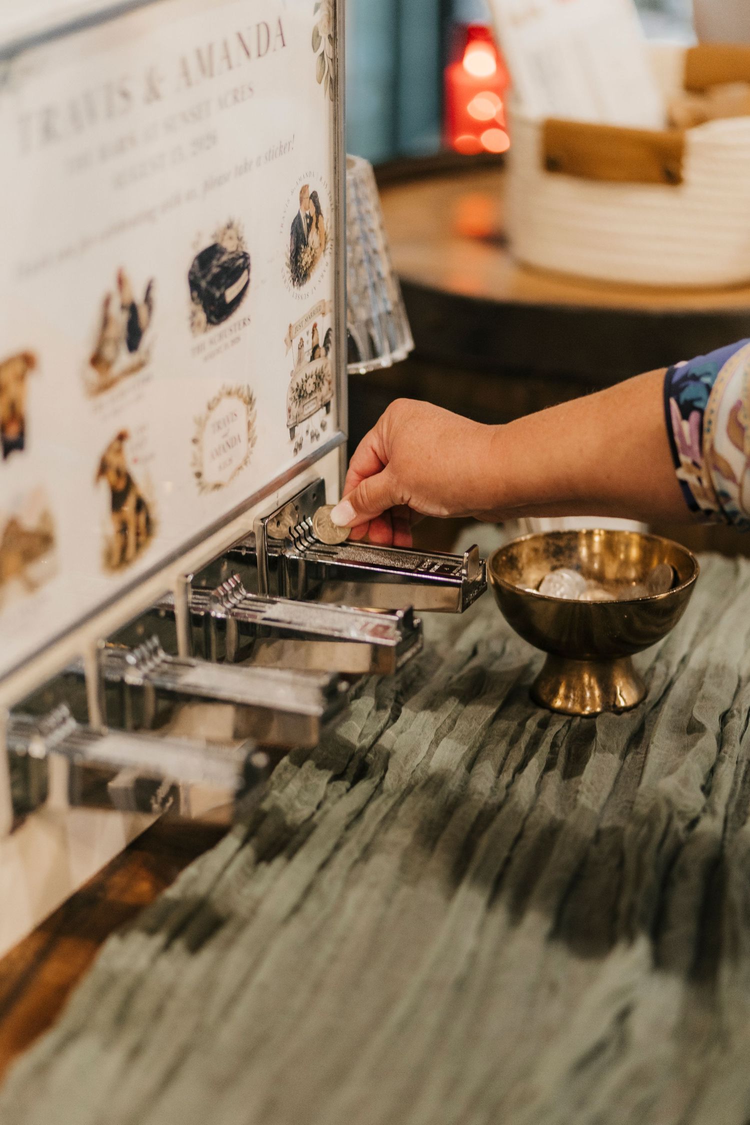 Hand placing item in vintage card holder beside gold bowl on marble table at Travis and Amanda wedding reception.