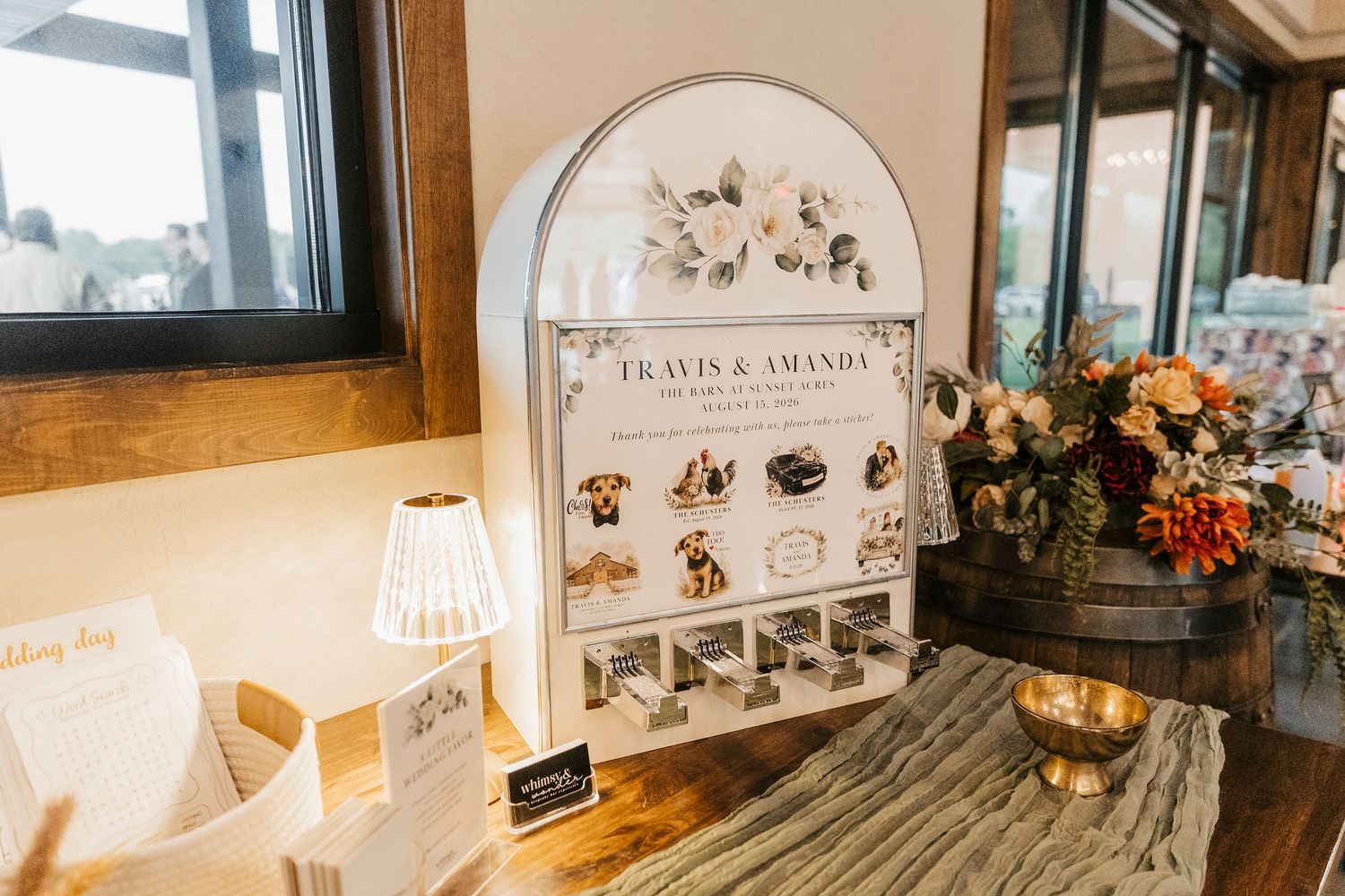 Wedding sign display for Travis & Amanda featuring photos and floral arrangements on a rustic wooden table.