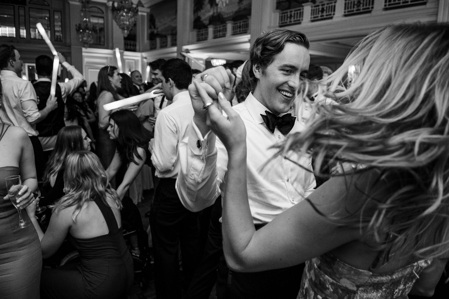 People dancing and socializing at a lively party in black and white photography.