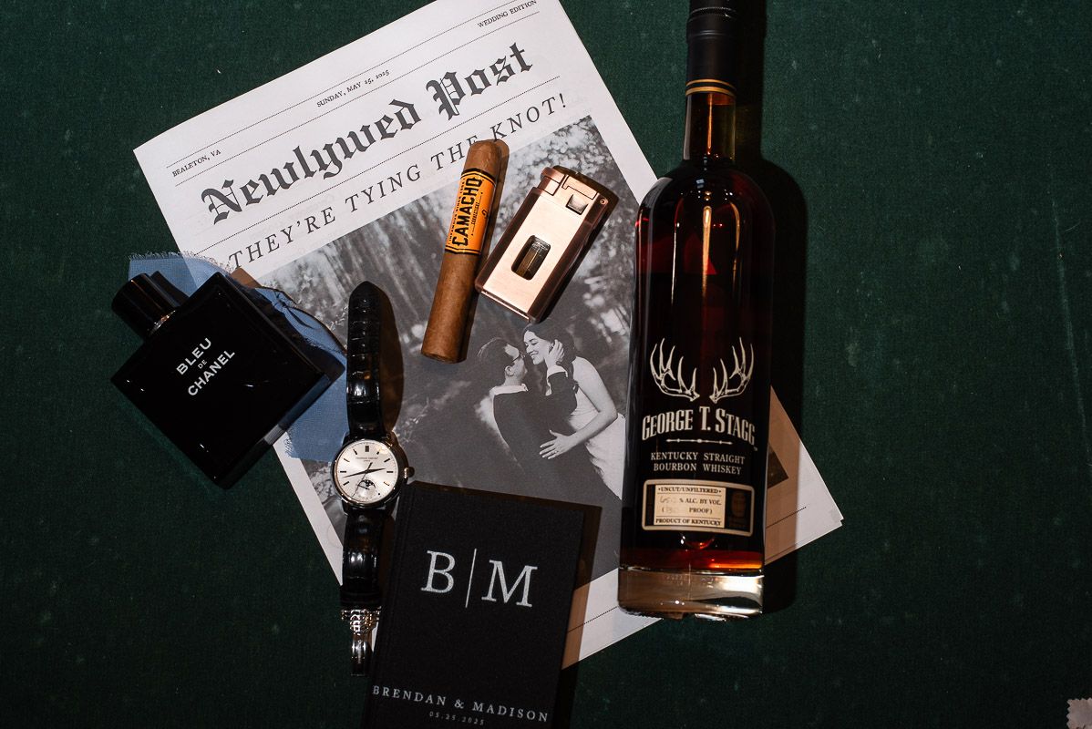 A collection of bourbon whiskey bottles and books arranged artistically against a dark background.