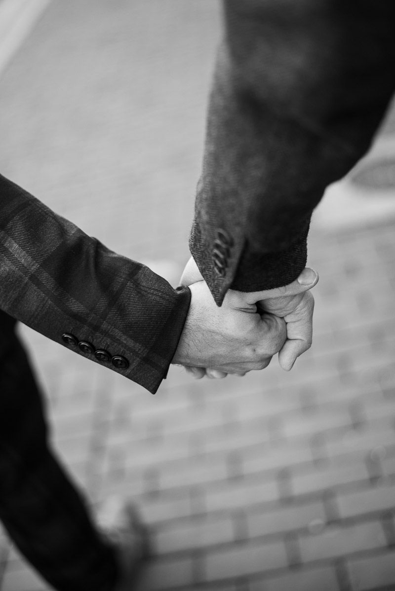 Black and white image sequence showing hands reaching out to hold each other in a progressive motion.