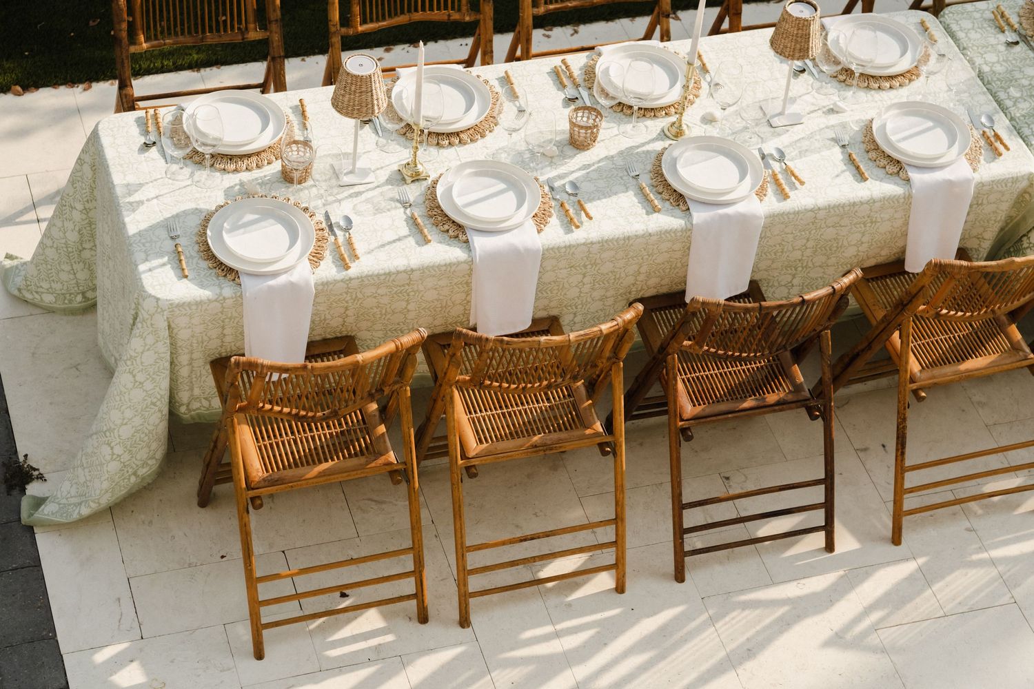 Elegant wedding reception table setup with white linens, gold chairs, and place settings in a rustic wooden venue.