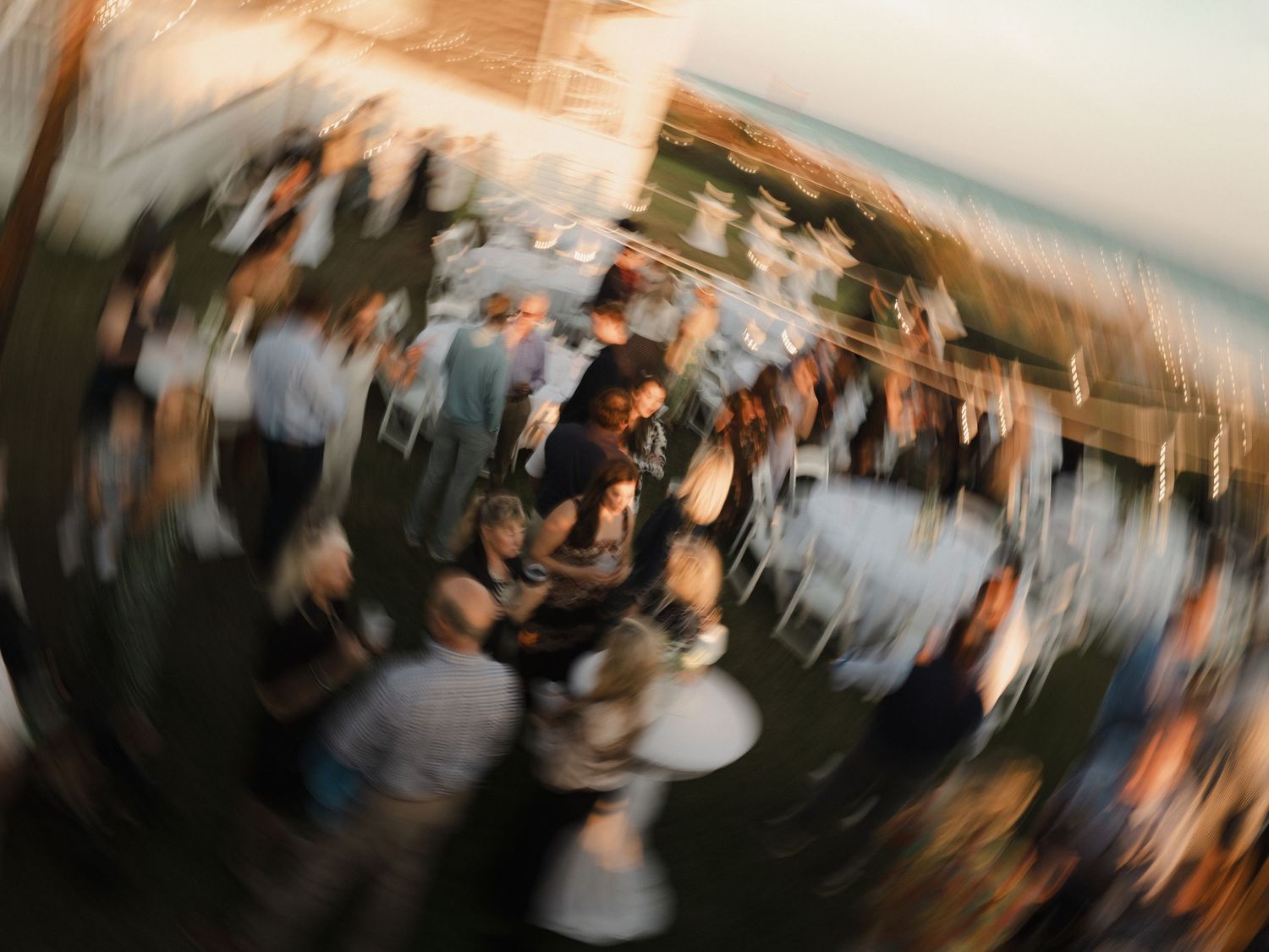 A blurred motion sequence of people dancing at a party or celebration creates a dynamic sense of movement.