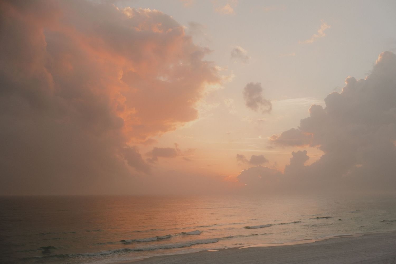 Dramatic orange sunset sky over calm ocean waters.