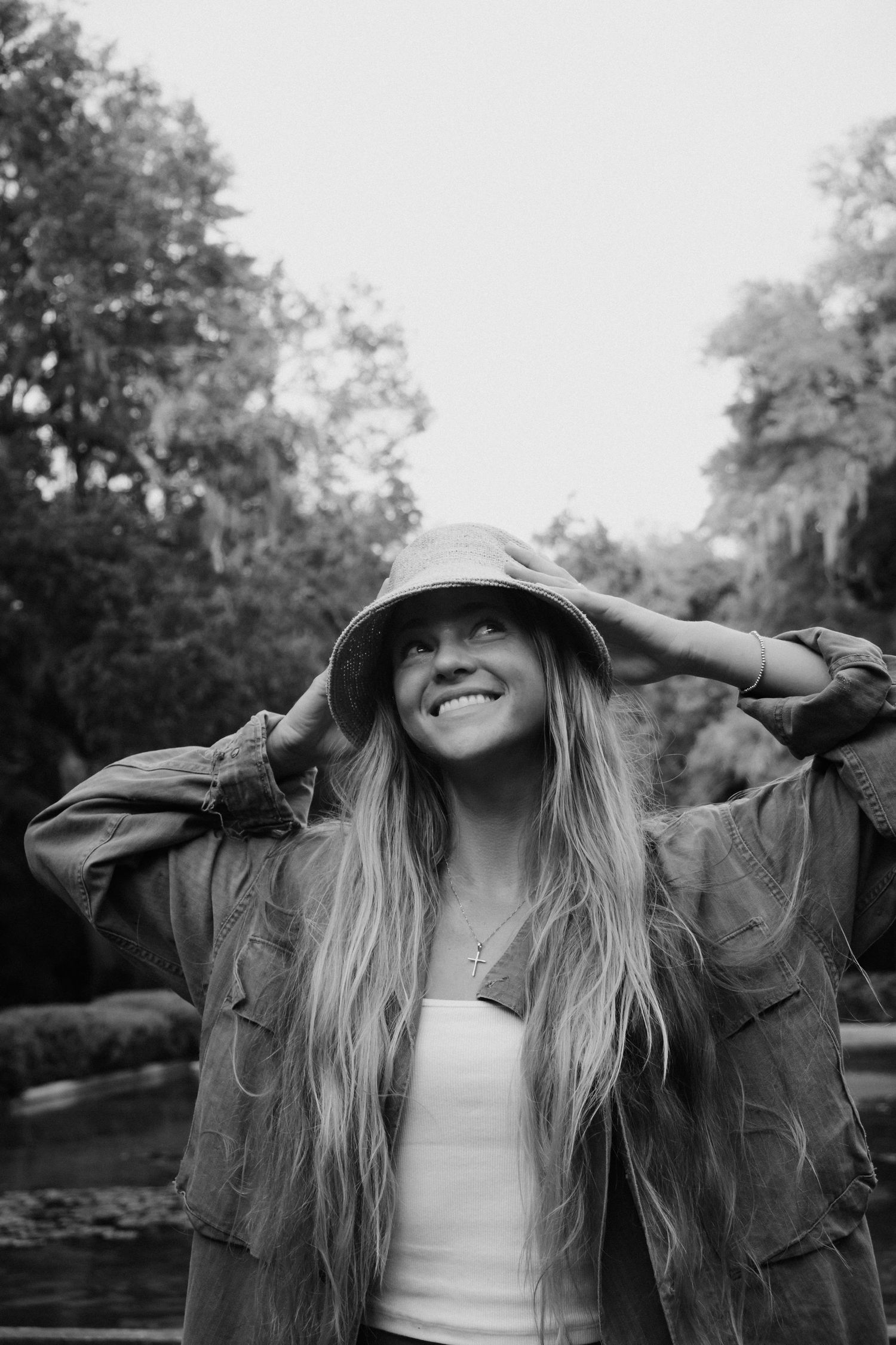 A black and white photo series shows someone in a jacket and hat enjoying a carefree moment outdoors.